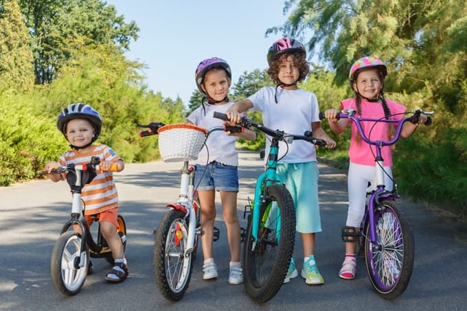 ヘルメットを被って自転車を手押ししている子どもたち